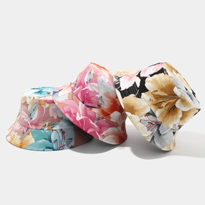 Three vibrant floral bucket hats with summer prints in pink, blue, and yellow colors