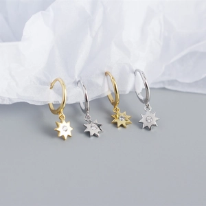 Detail of S925 silver star pendant earrings with gold and silver finishes and zircon stones