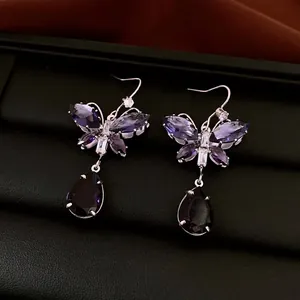 Elegante Schmetterlings-Ohrringe mit lila Zirkonia-Kristallen und Tropfenanhänger auf Box