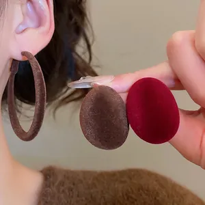 Boucles d'oreilles ovales floquées marron et bordeaux avec une texture veloutée