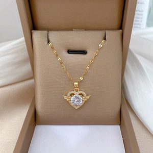 Detail of gold angel heart necklace with zircon wings in a brown jewelry gift box