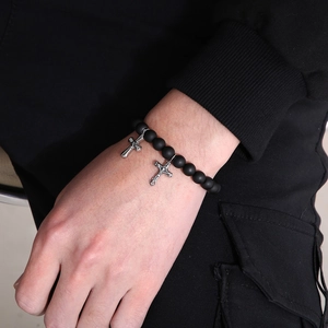 Detailaufnahme des Perlenarmbands mit schwarzen Steinen und Silberkreuz-Anhängern für Herren