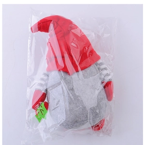Close-up of a Christmas gnome plush toy in a protective bag showing red and grey colors