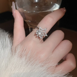 Macro view of rotating snowflake ring with zircons worn elegantly holding a glass