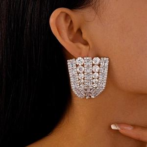 Close-up of oversized silver-toned statement earrings with fan-shaped cubic zirconia crystals