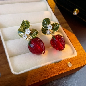 Elegant strawberry earrings with red crystals and white flowers in a wooden jewelry box