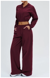 Detail of burgundy windproof hooded jacket and wide-leg sport trousers set