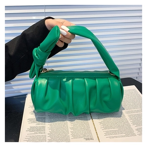 Detail of green ruched cloud bag showing soft leather texture and knotted handle