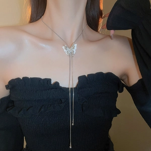 Close-up of elegant butterfly tassel necklace worn on model for stylish luxury look