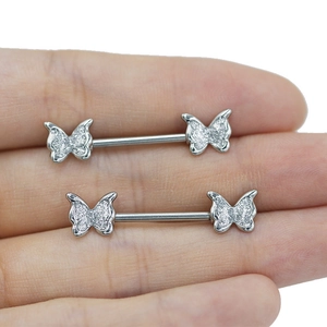 Detail view of heart-shaped butterfly nipple rings in silver finish held by hand