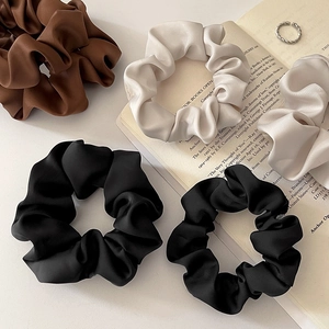 Silk satin scrunchie set in brown, beige, and black on a book, elegant hair accessories