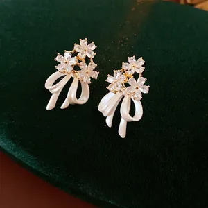 Boucles d'oreilles nœuds et fleurs en plaqué or avec cristaux de zircone cubique