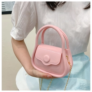 Close-up of pink macaron jelly mini bag with golden metal chain strap and glossy finish
