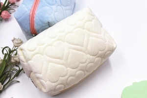 Close-up of plush pillow pencil cases with heart pattern in white and blue colors