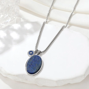 Vintage necklace with blue lapis lazuli and silver sun pendant on white stone