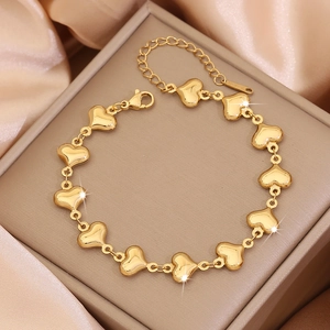 Elegant gold heart link bracelet crafted in stainless steel on a soft silk background
