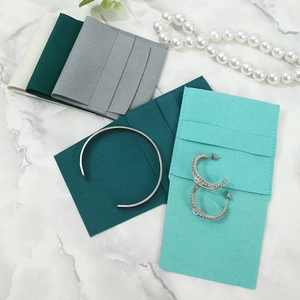 Premium microfiber suede jewelry pouches in assorted colors on marble background