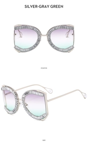 Detail of oversized sun glasses with rhinestone frame, gradient lenses and pearl temple tips