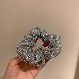 Close-up of sparkling silver rhinestone scrunchie with brilliant light reflection