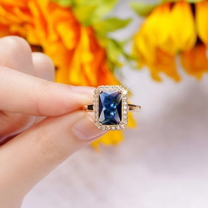 Detailed close-up of a vintage gold ring featuring a large emerald-cut blue gemstone