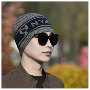 Gros plan du bonnet en tricot gris et bleu avec motif NY pour un style hivernal décontracté