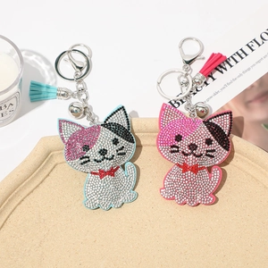 Detail of pink and light blue rhinestone cat keychain with tassel and soft bell