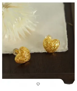 Macro shot of gold woven texture heart earrings with comfortable silicone backings