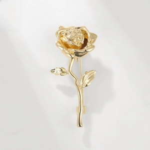Detailed close-up of a realistic golden rose brooch with layered petals and metallic stems