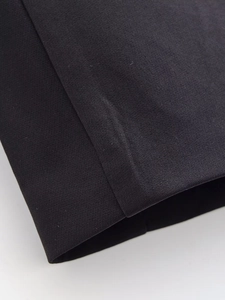 Gros plan sur la texture du tissu noir et les coutures professionnelles du revers de manche