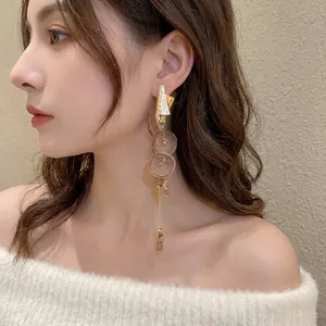 Elegant gold earrings with brown chiffon flowers and marble pendant on model