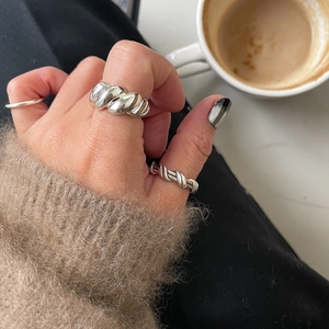 Close-up of a silver irregular twisted rope ring on a finger in a lifestyle setting