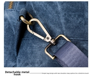 Close-up of vintage bronze hardware hook on blue denim backpack with durable grey strap