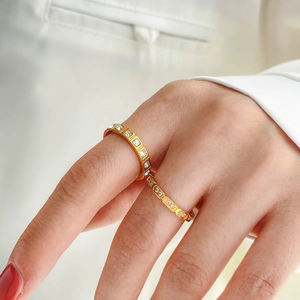 Close-up of golden stackable rings with sparkling baguette and round-cut cubic zirconia