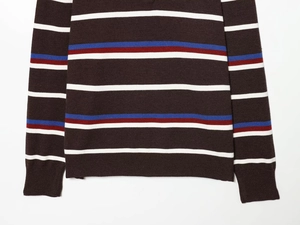 Detail of knit fabric texture with navy blue and red striped pattern on brown sweater