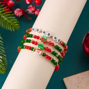 Dettaglio del set di braccialetti natalizi con ciondoli HO HO HO su base bianca