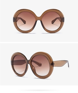 Detail view of oversized round tortoiseshell sunglasses with brown gradient lenses
