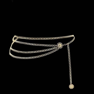 Detail of multilayer golden metal waist chain with sun flower charm and layered curb links