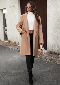 Chic camel mid-length wool coat styled with black leggings and boots for a commute look