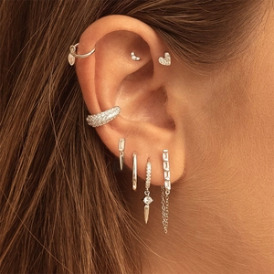 Close-up of silver earrings set with sparkling zircons worn on a female model