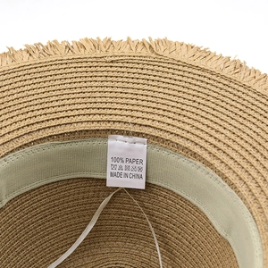 Internal view of summer paper straw sun hat with raw edges and wash care label details