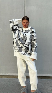 Close-up of knit texture and rabbit pattern on casual white sweater and trousers set