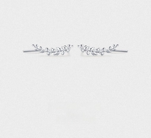 Detail view of silver leaf-shaped earrings featuring a minimalist and elegant nature design