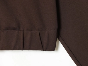 Detail view of the deep brown ribbed hem and precision stitching on high-quality fabric