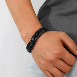 Men's double-layered black braided leather bracelet with cylinder beads on a wrist