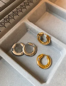Detailed macro view of gold and silver plated hoop earrings with inlaid zircons on velvet
