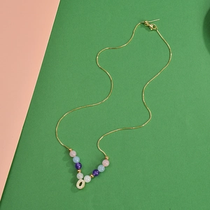 Collier de perles rhodochrosite 6mm doré avec un pendentif initiale O en zircon cristal