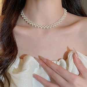 Close-up of double-layer woven pearl necklace with shimmering white beads on neck