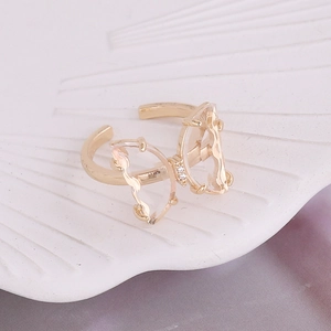 Macro view of gold butterfly ring with hollow wings and sparkling crystal details