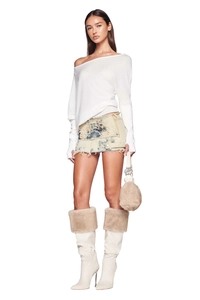 Full view of asymmetric off-shoulder white sweater with denim mini skirt and fur boots