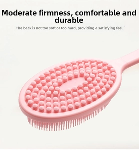 Close-up of pink dual-sided silicone bath brush showing massage nodes and soft bristles